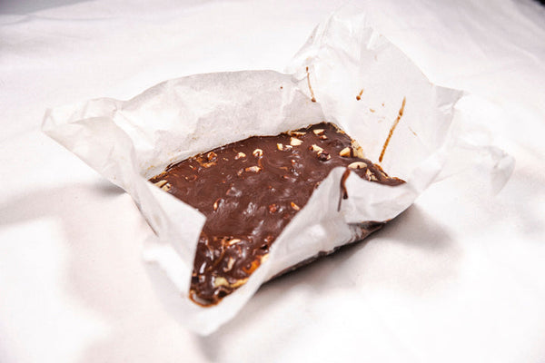 Three-layered almond bars with chocolate and nuts on a plate