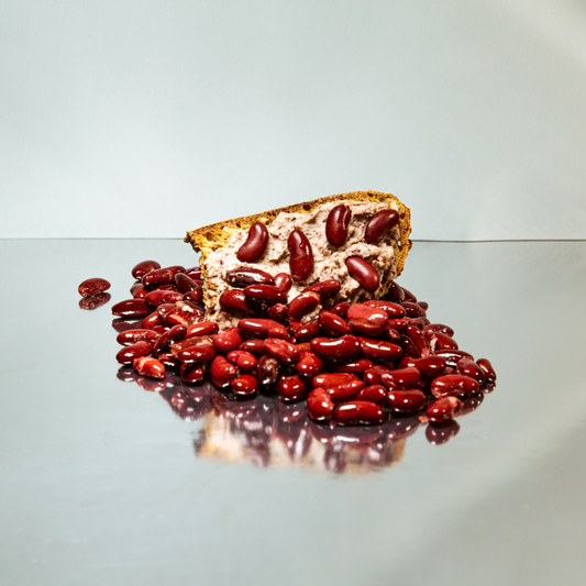 Creamy red bean spread with feta and pine nuts in a bowl, drizzled with olive oil