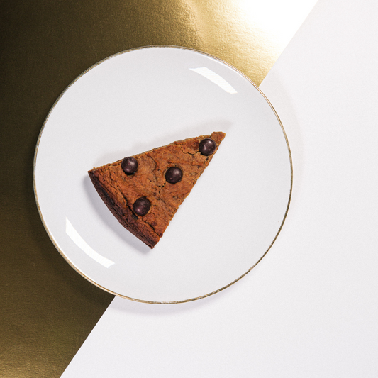 Sliced chickpea cake with dark chocolate chips on a wooden board
