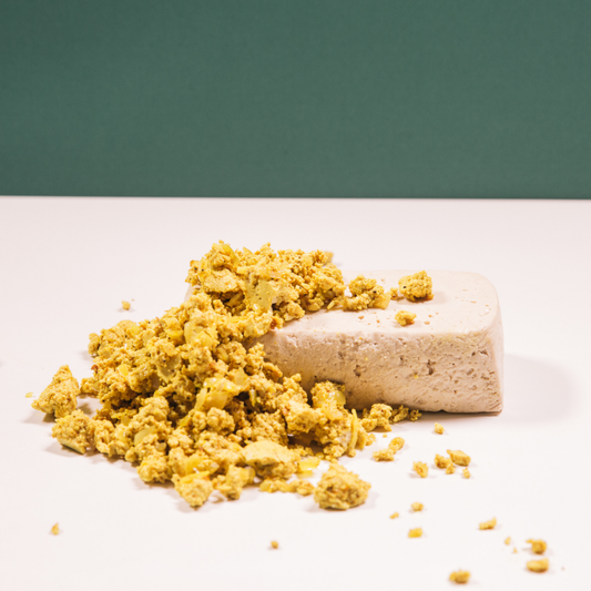 Scrambled tofu seasoned with curry powder and leek, served on a plate with avocado toast